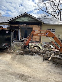 an excavator is being used to demolish a house